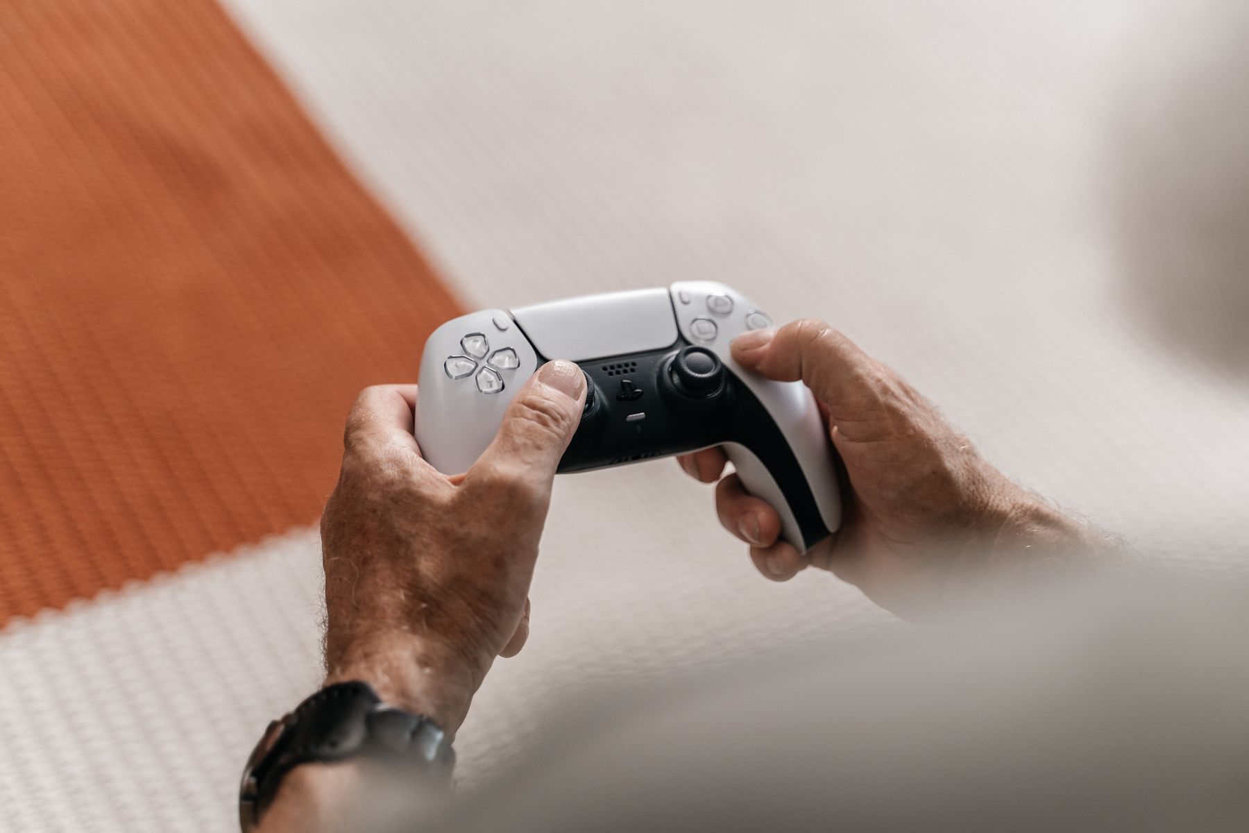 Ältere Hände halten einen modernen Controller